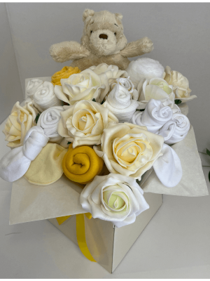 Winnie Pooh Clothing Bouquet with a selection of rolled baby clothes arranged to look like a bouquet of flowers in a vase