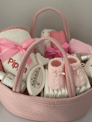 Pink nappy caddy that is filled with practical baby changing products including lotions. 15 separate items all gift wrapped with large bow and ribbons