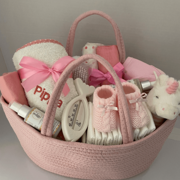 Pink nappy caddy that is filled with practical baby changing products including lotions. 15 separate items all gift wrapped with large bow and ribbons