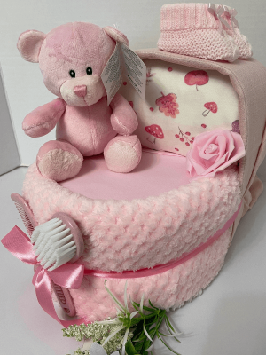 Pink Ted Nappy Crib that is a nappy cake filled with baby nappies surrounded in a blanket and products to create the look of a baby crib