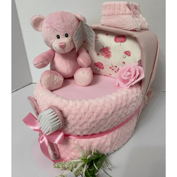 Pink Ted Nappy Crib that is a nappy cake filled with baby nappies surrounded in a blanket and products to create the look of a baby crib