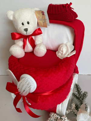 Nappy Cake Pram Red, a baby gift in the shape of a pram that is curated from practical baby products and includes a white baby 1st bear.